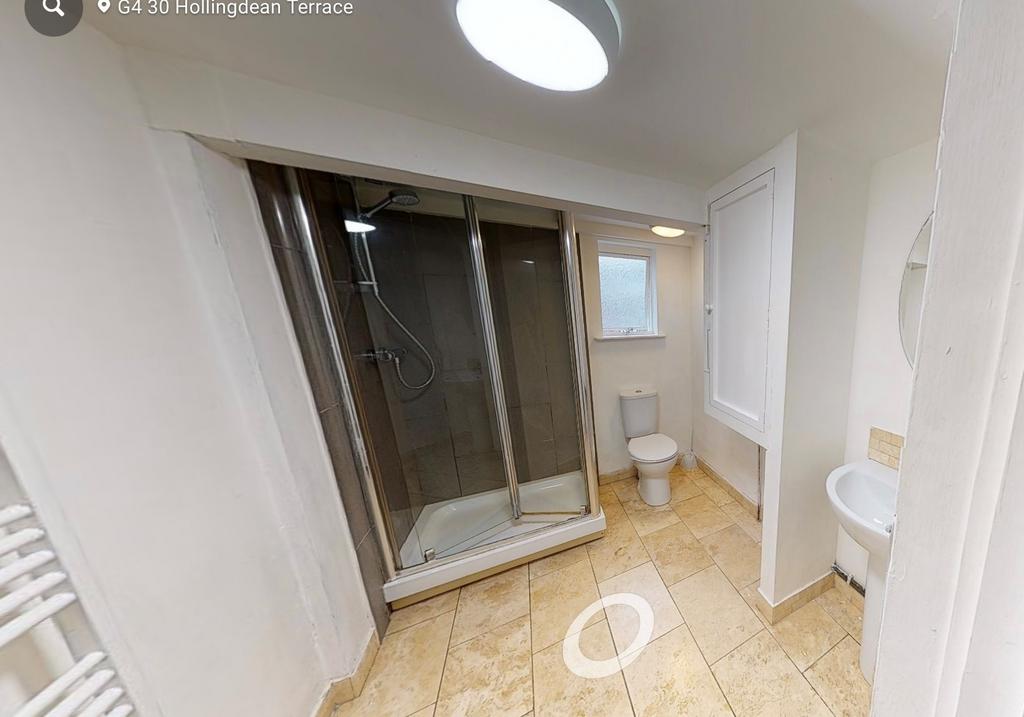 Bright, clean bathroom featuring a modern glass...