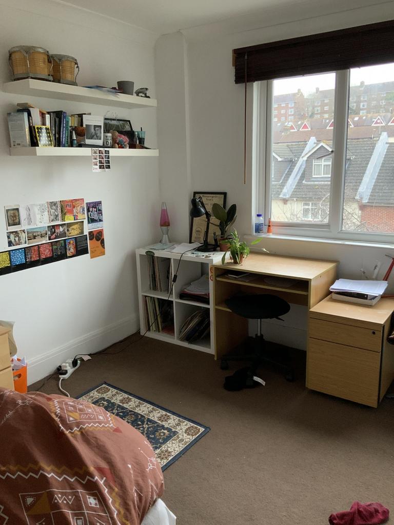 A cozy and well-lit bedroom with a large window...