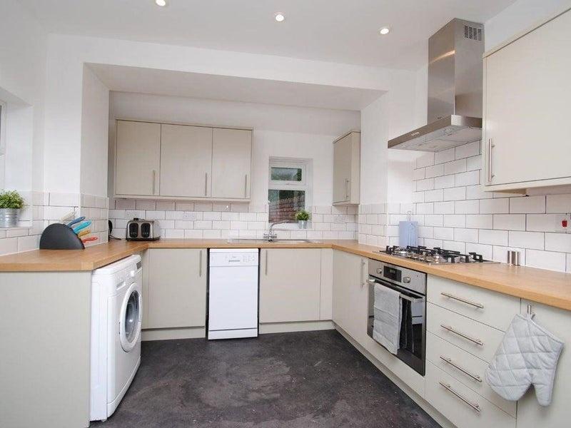 Bright modern kitchen with neutral cabinetry, w...