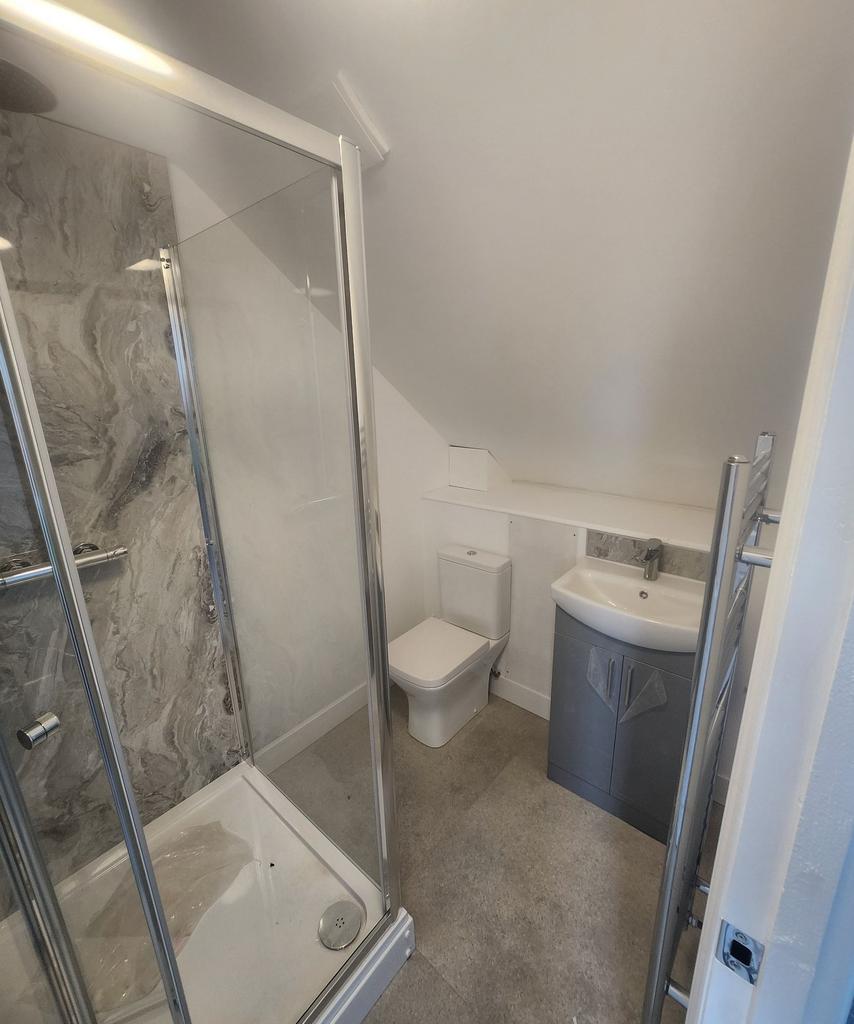 Modern compact bathroom with a corner shower en...