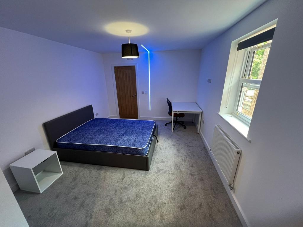 Bright, modern double bedroom with a comfortabl...