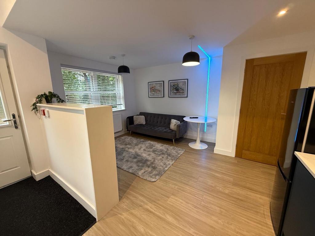 Bright, modern living area with a grey upholste...