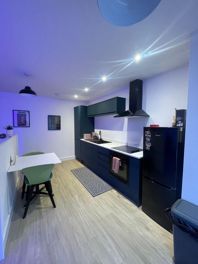Modern fitted kitchen with dark cabinetry, inte...