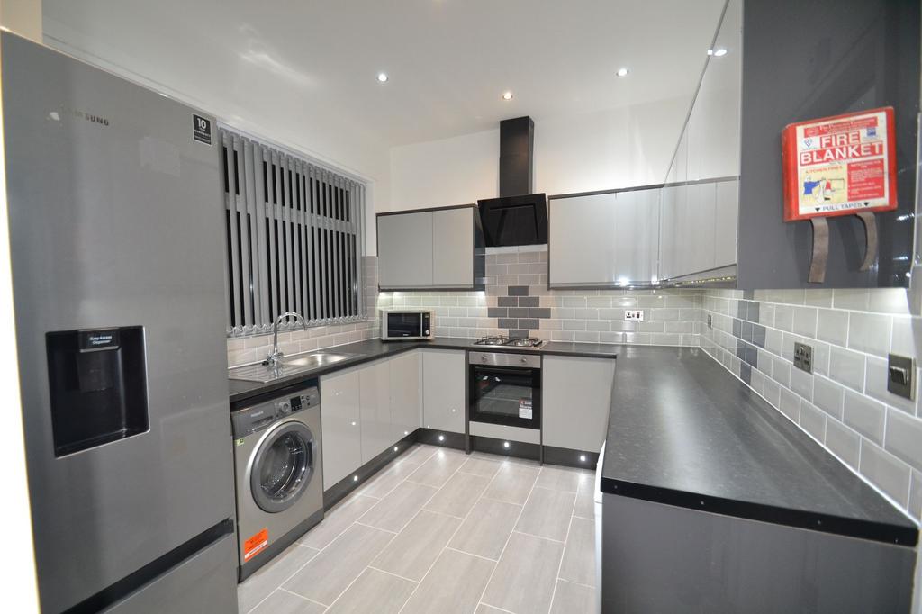 Contemporary fully fitted kitchen with sleek gr...