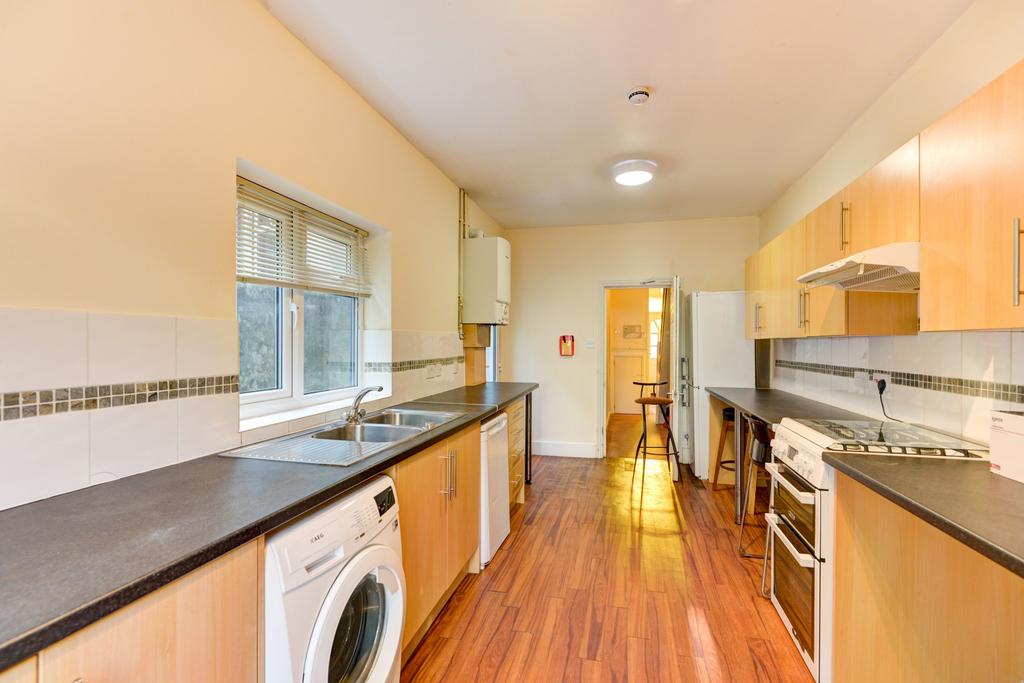 Long galley kitchen with wood-effect flooring, ...