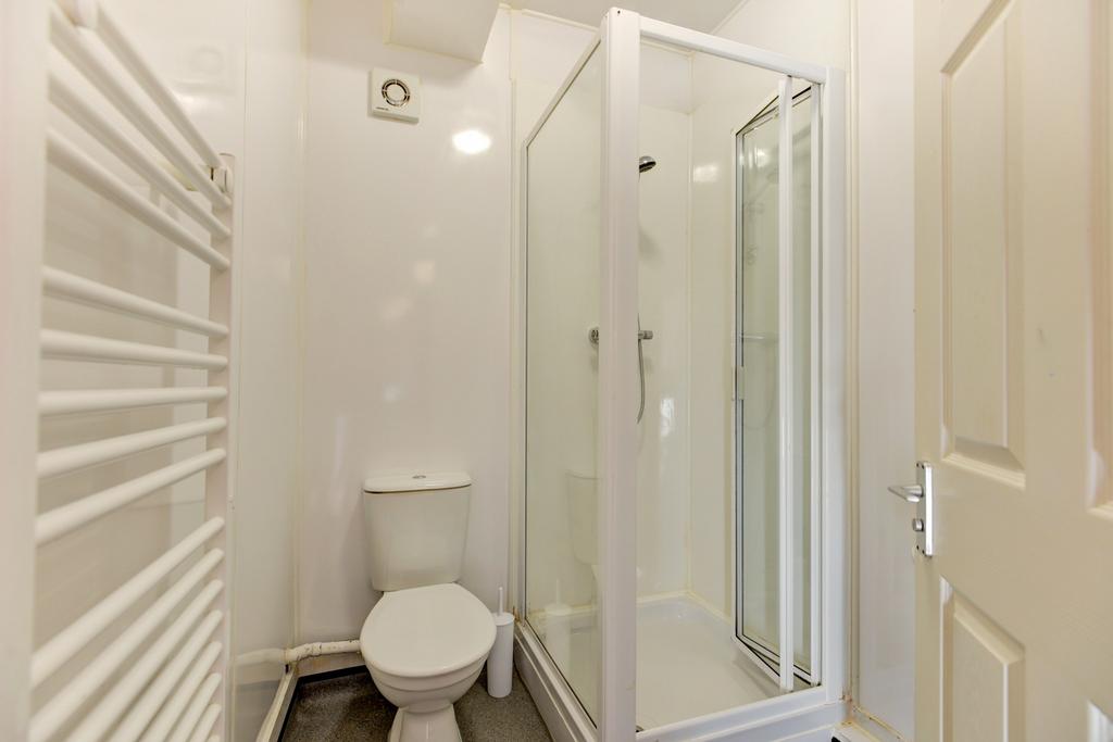 Bright, modern bathroom with a corner shower en...
