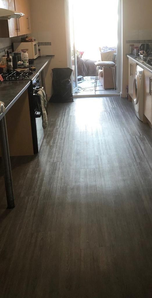 Long galley kitchen with modern flooring, integ...