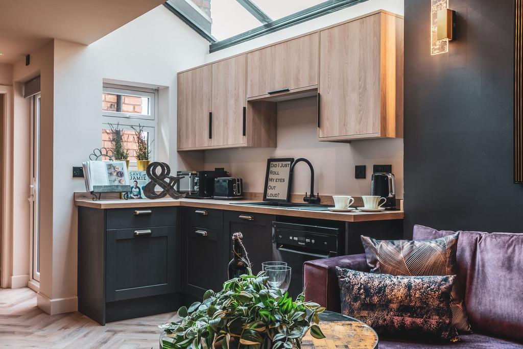 Stylish open-plan kitchen area with light wood ...