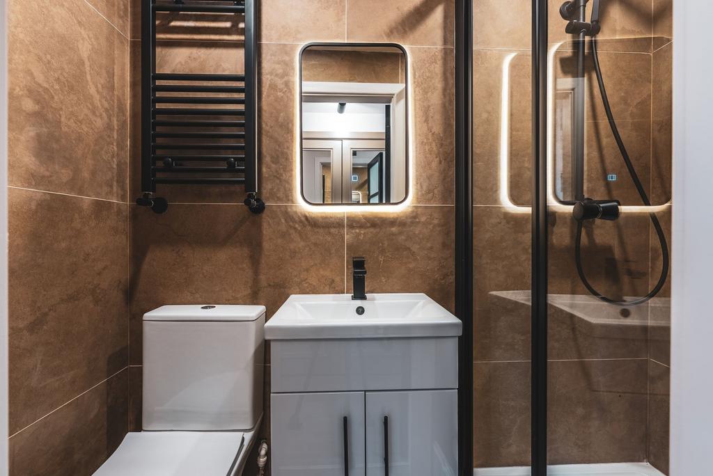 Modern ensuite bathroom with warm stone-effect ...