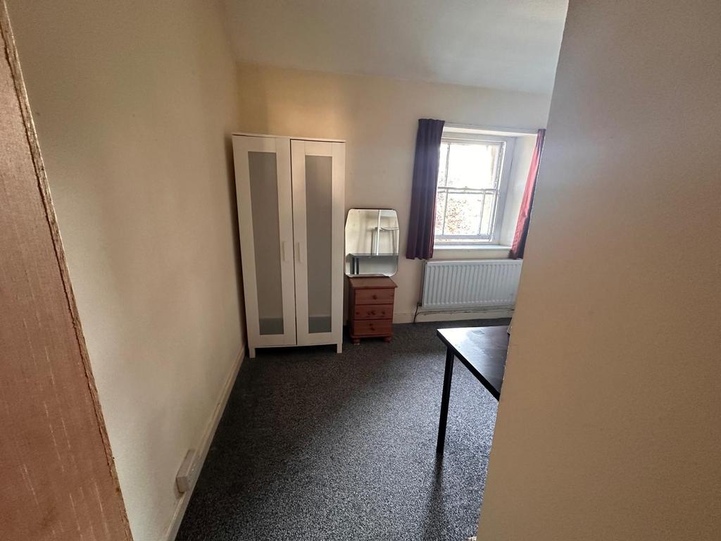 Simple, neutrally decorated bedroom with a ward...