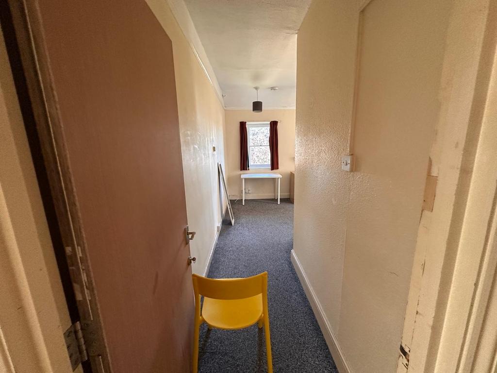 Long internal hallway with neutral walls, fitte...