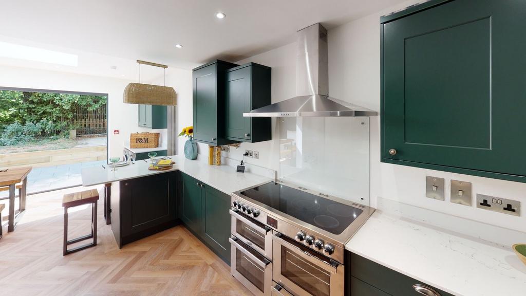 Modern kitchen with sleek dark green cabinetry,...