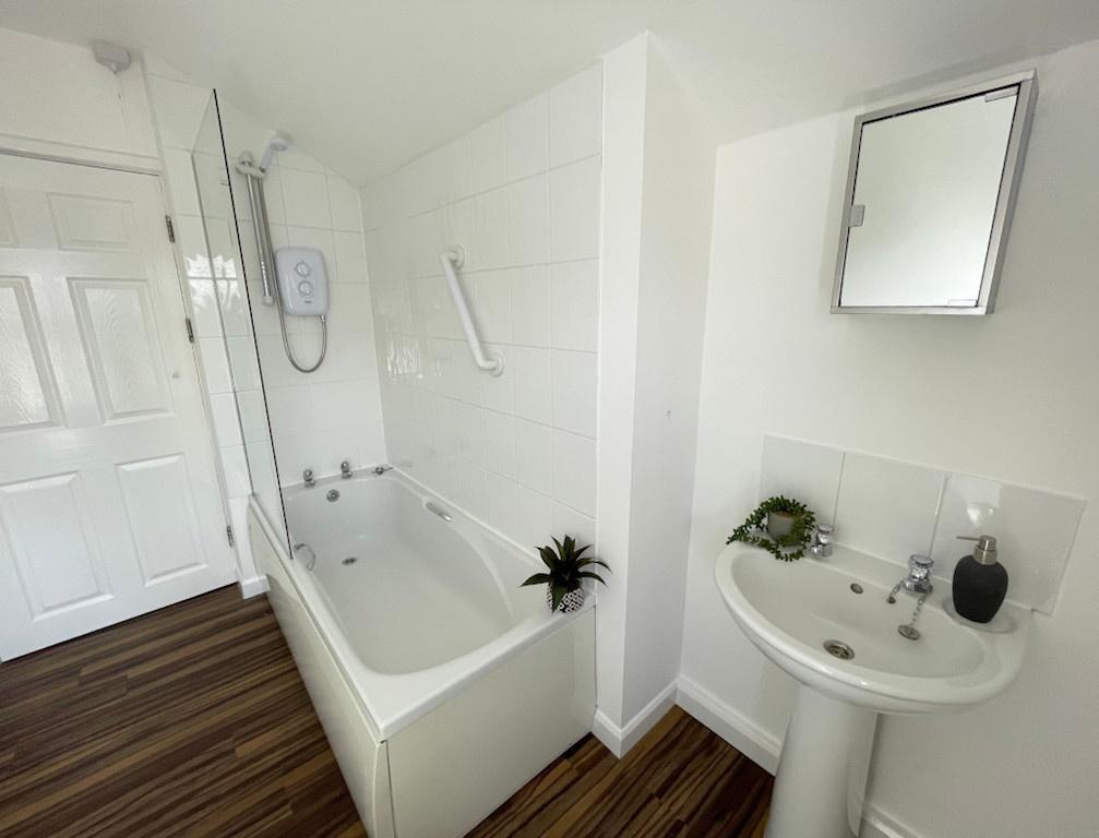 Bright, modern bathroom with a fitted bath and ...