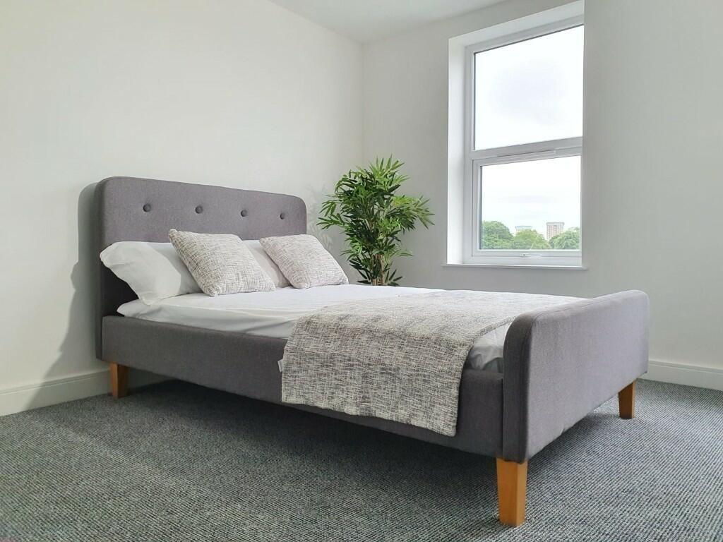 A spacious, well-lit master bedroom featuring a...