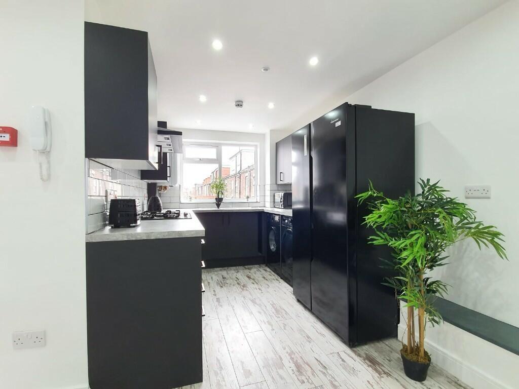 A modern kitchen featuring sleek black cabinets...