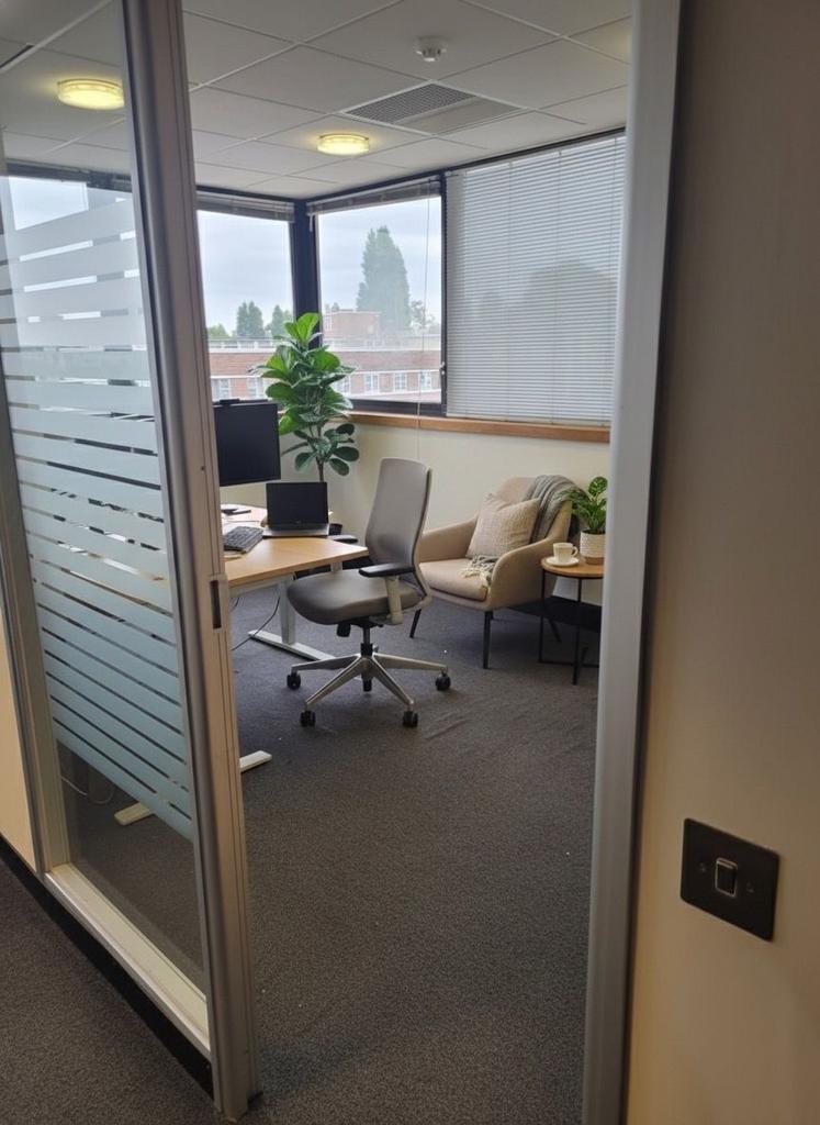Bright, modern corner workspace with large wind...