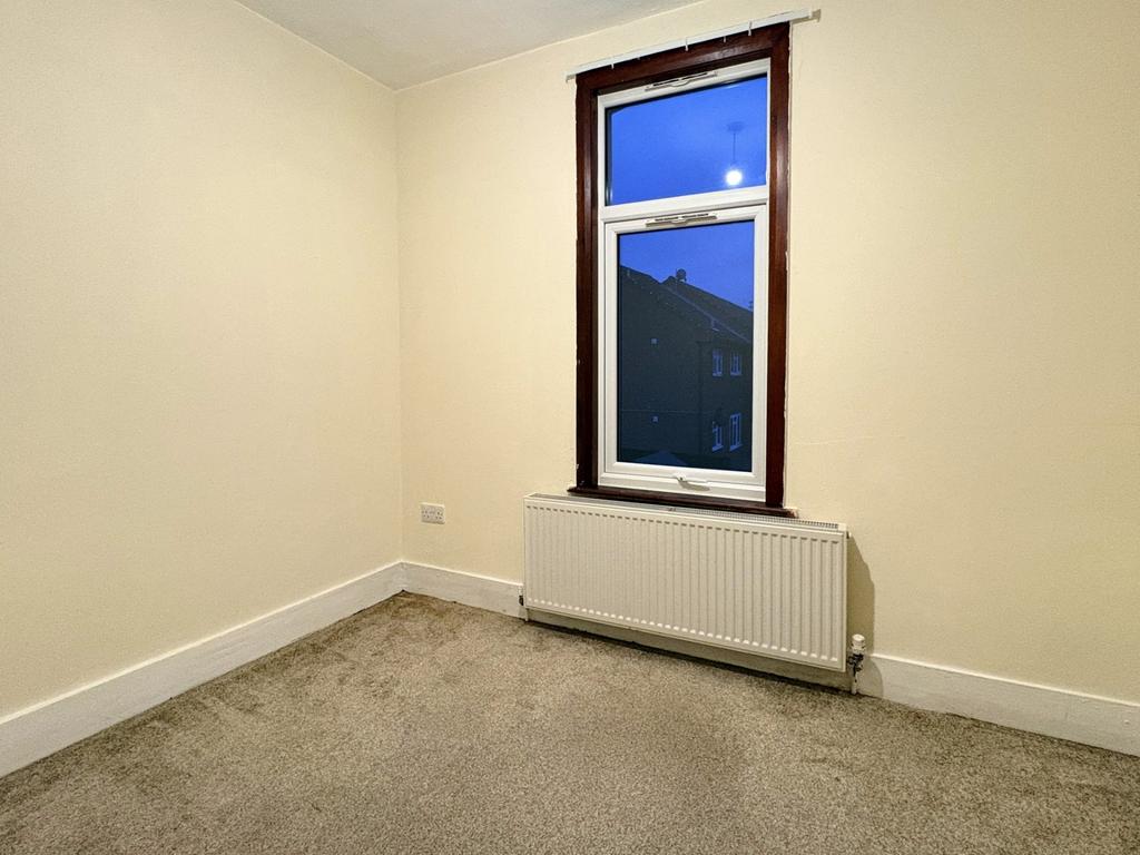 Simple single bedroom with a large sash window,...