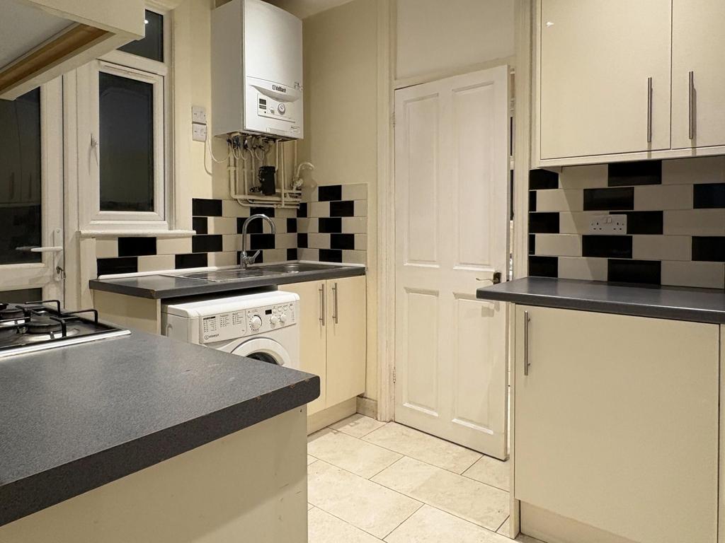 Well-maintained fitted kitchen with cream cabin...