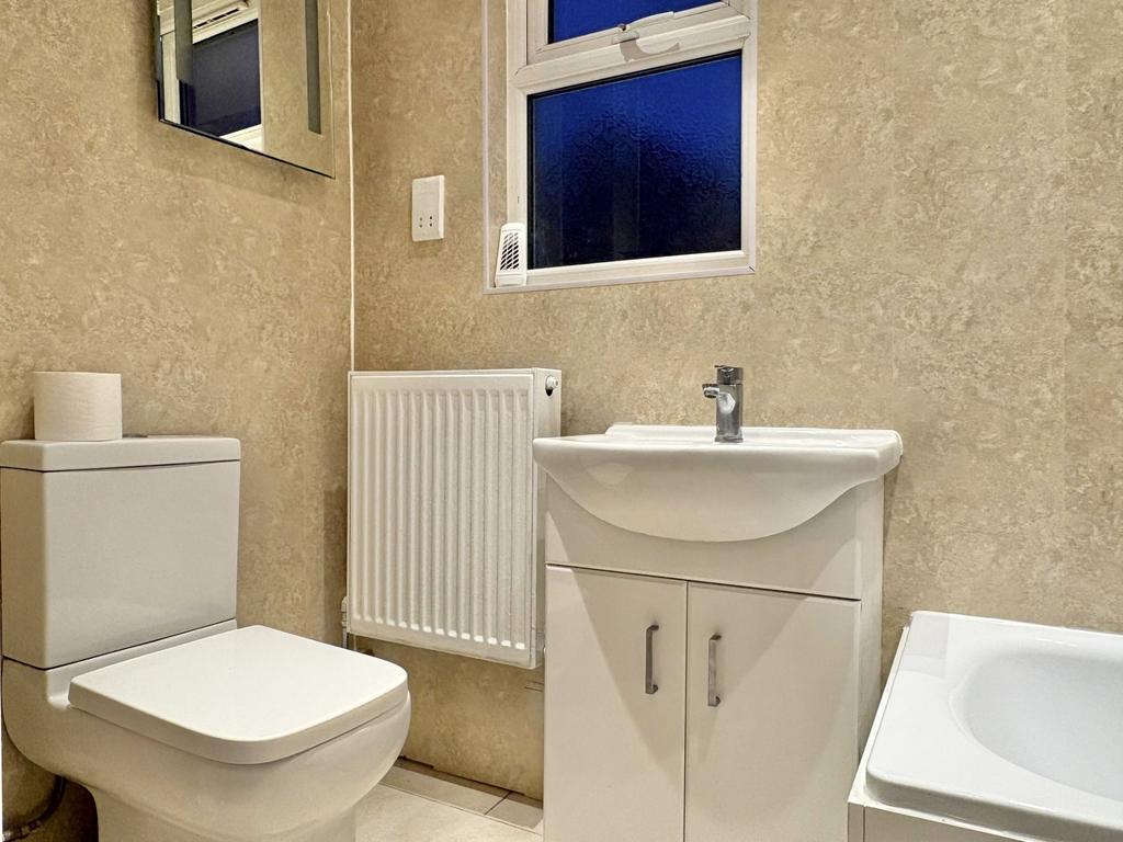 Modern bathroom with white suite including a to...