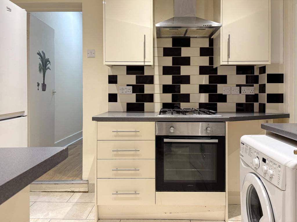 Modern compact kitchen with patterned black-and...