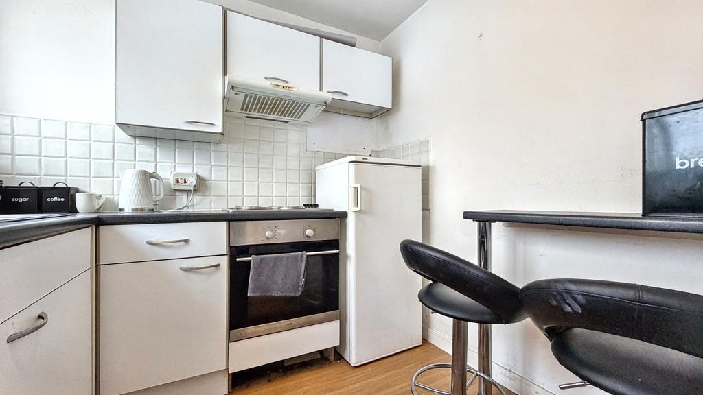 Compact modern kitchen with integrated oven, ho...