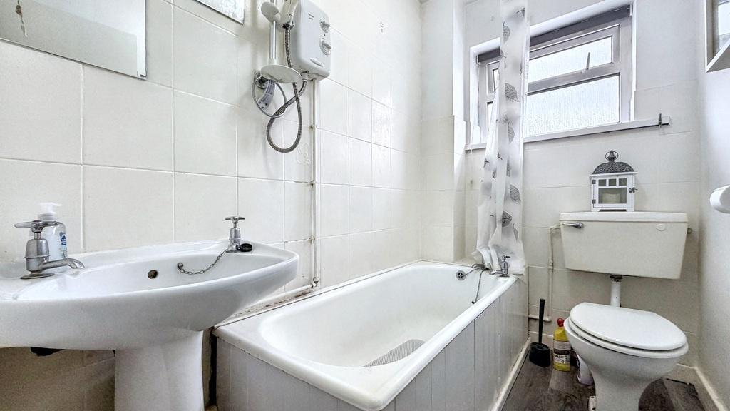 Bright, well-maintained bathroom with a white b...