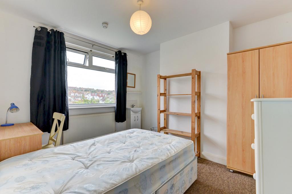 Bright, simply furnished bedroom with a large w...