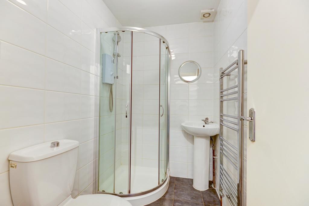 Bright, modern bathroom with a curved glass sho...