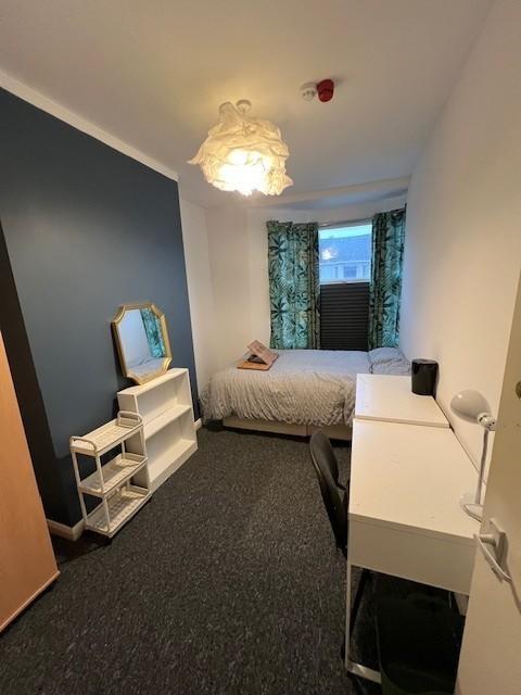 Neat single bedroom with a single bed by the wi...