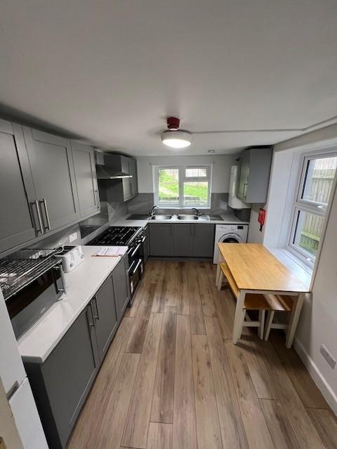 Modern galley kitchen with grey cabinetry, inte...