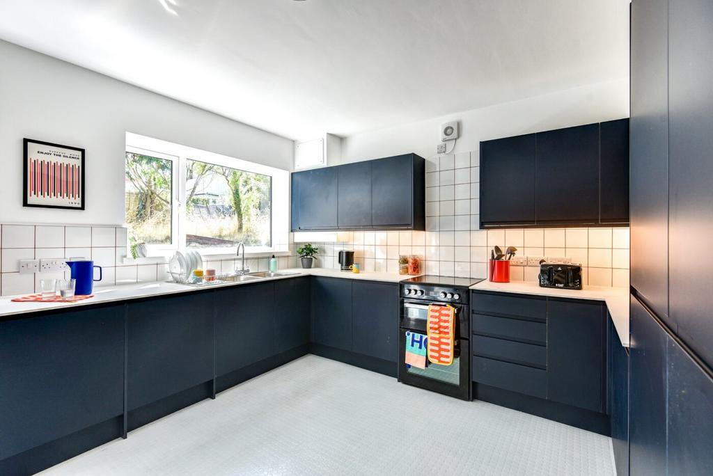 Modern kitchen with dark blue cabinets, large w...