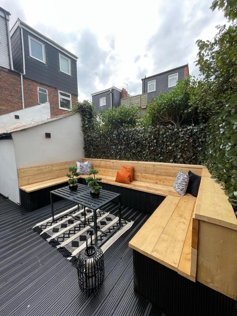 A cozy outdoor patio area with built-in wooden ...