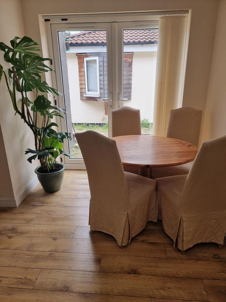 Bright dining corner with a round wooden table ...