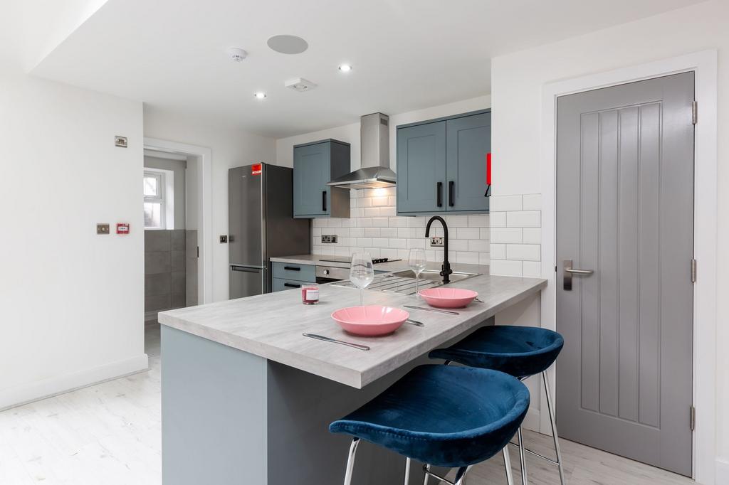 Modern, stylish kitchen featuring blue cabinetr...