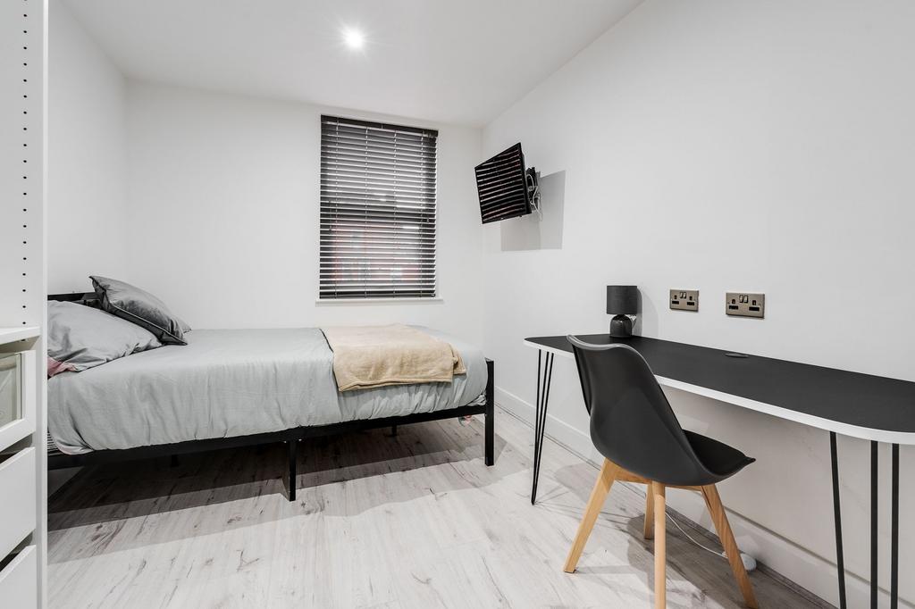 A bright and modern student bedroom featuring m...