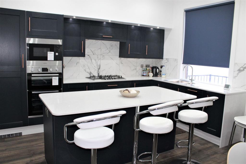Modern kitchen featuring sleek dark cabinetry w...