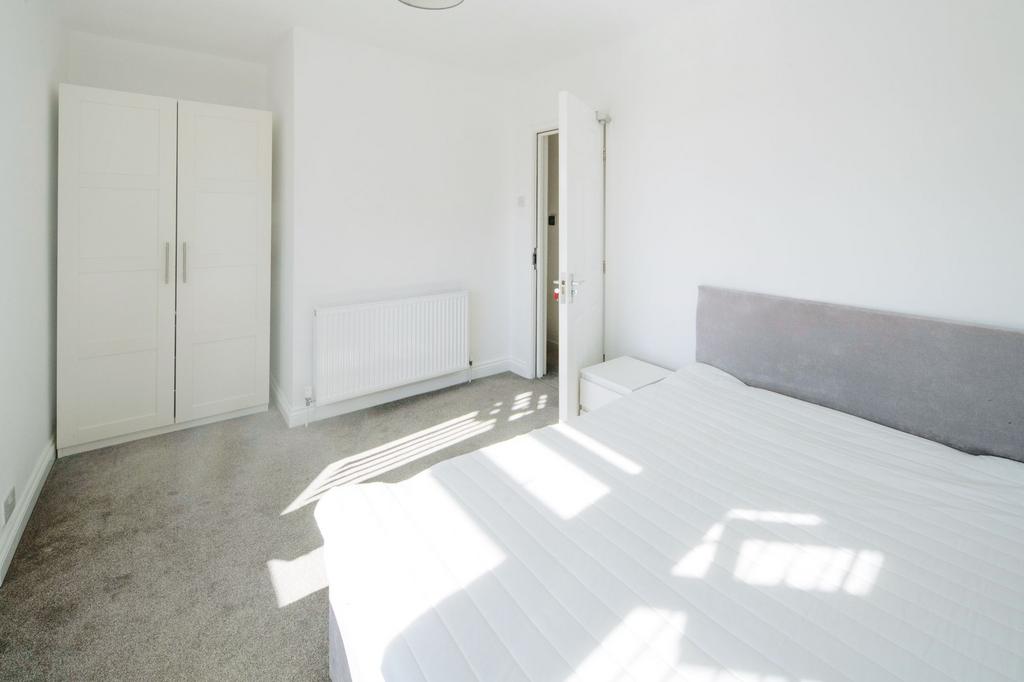 Bright, minimally furnished bedroom with a larg...