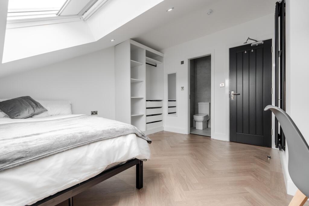 A spacious, well-maintained bedroom with a comf...