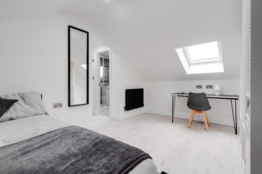A bright and modern bedroom with a skylight win...