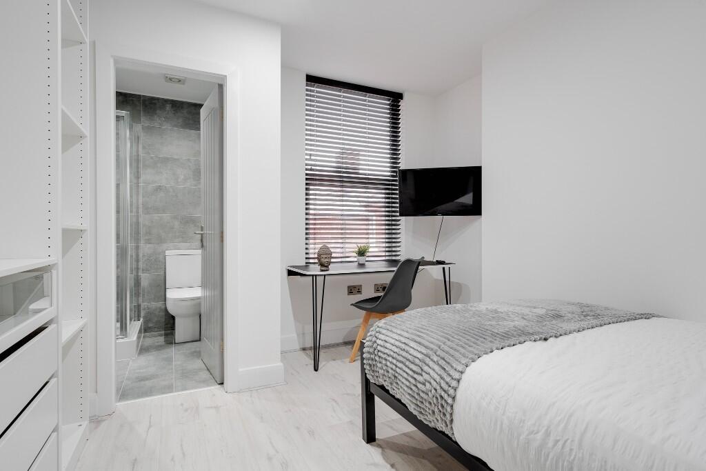 A bright and modern bedroom featuring a large b...