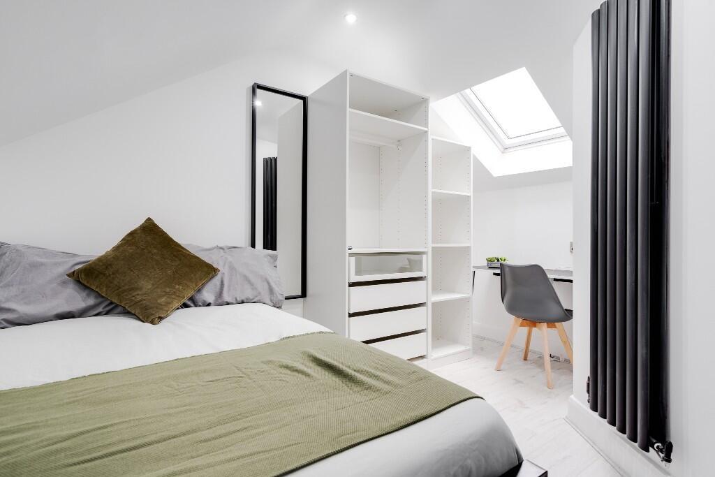 A bright and modern bedroom featuring a double ...