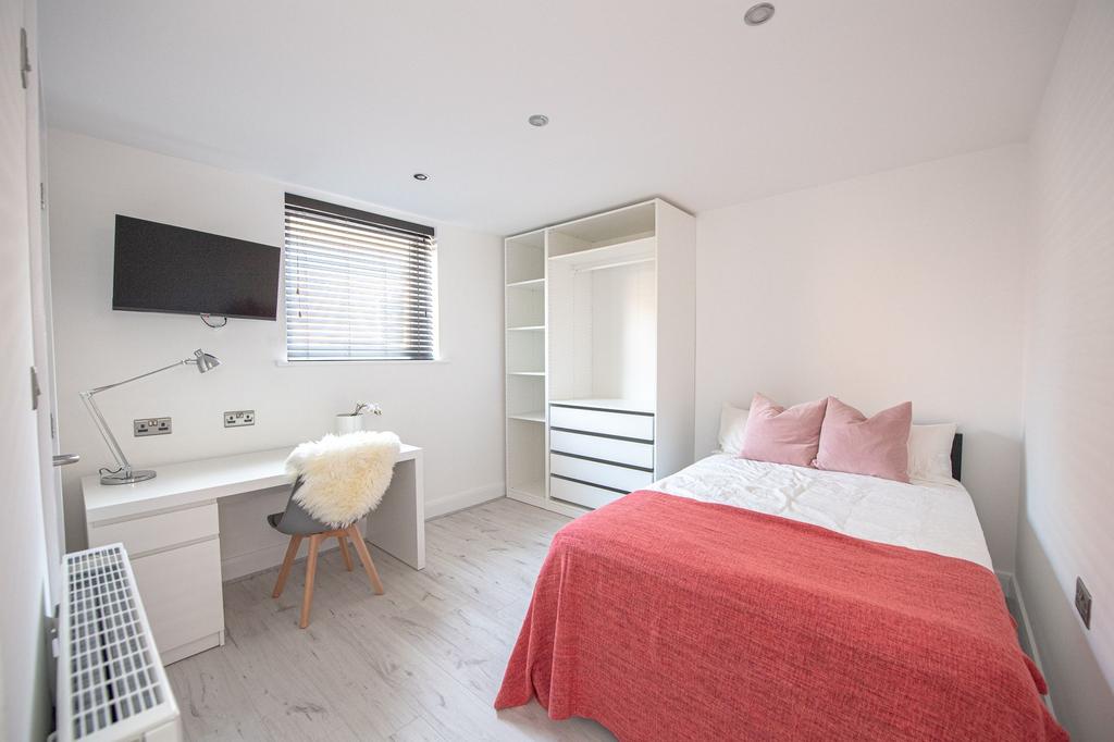 Bright and modern bedroom featuring a comfortab...