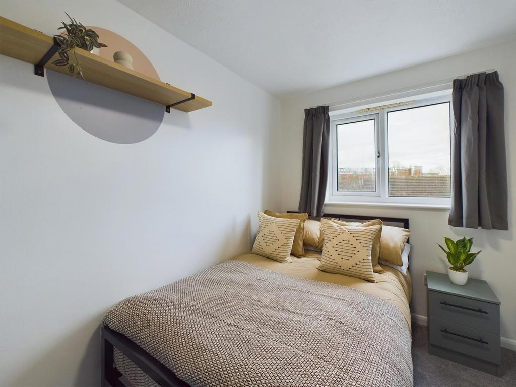 A cozy and well-lit double bedroom featuring mo...