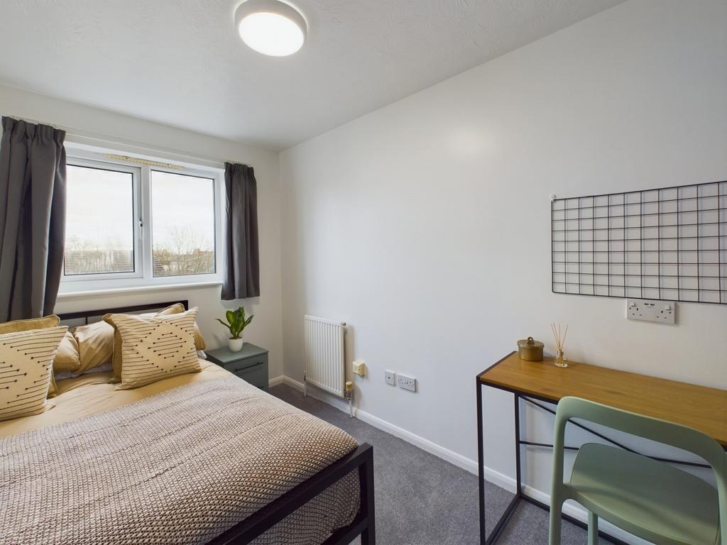 A bright and inviting double bedroom with a com...