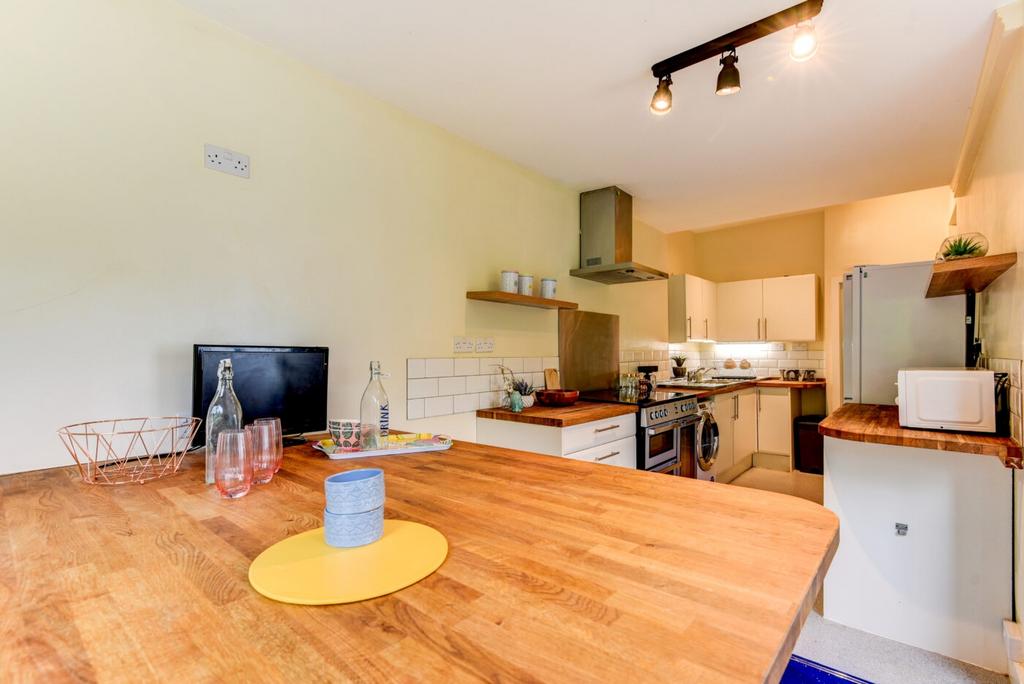A modern, well-lit kitchen with wooden countert...