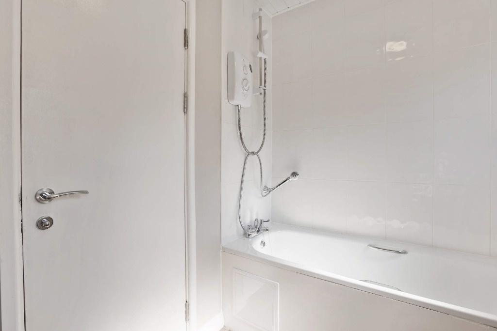 Bright, modern bathroom with a clean white bath...