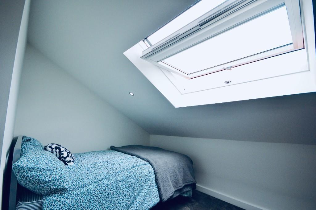 A bright and neat single bedroom featuring a co...