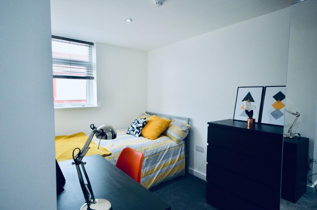 A bright and tidy small bedroom featuring a sin...