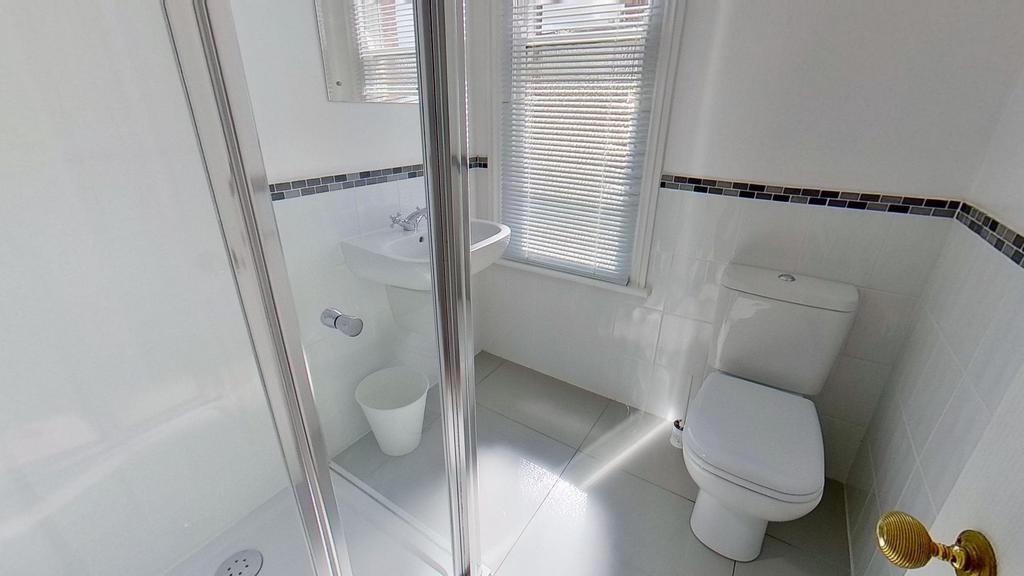 Bright, modern bathroom with a corner shower en...