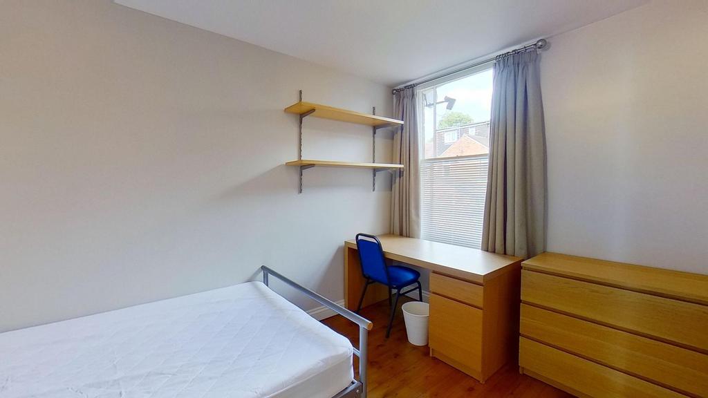 Bright, simply furnished bedroom with a single ...